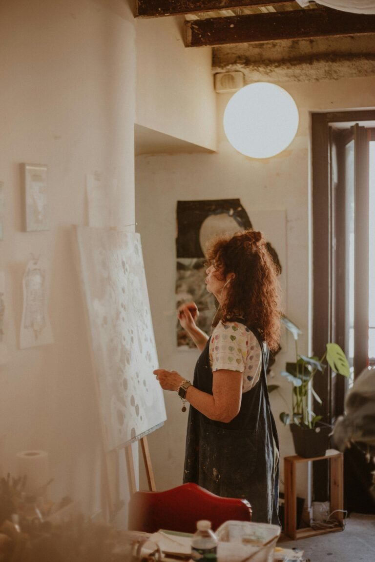 mujer pintando en un caballete dentro de una habitación