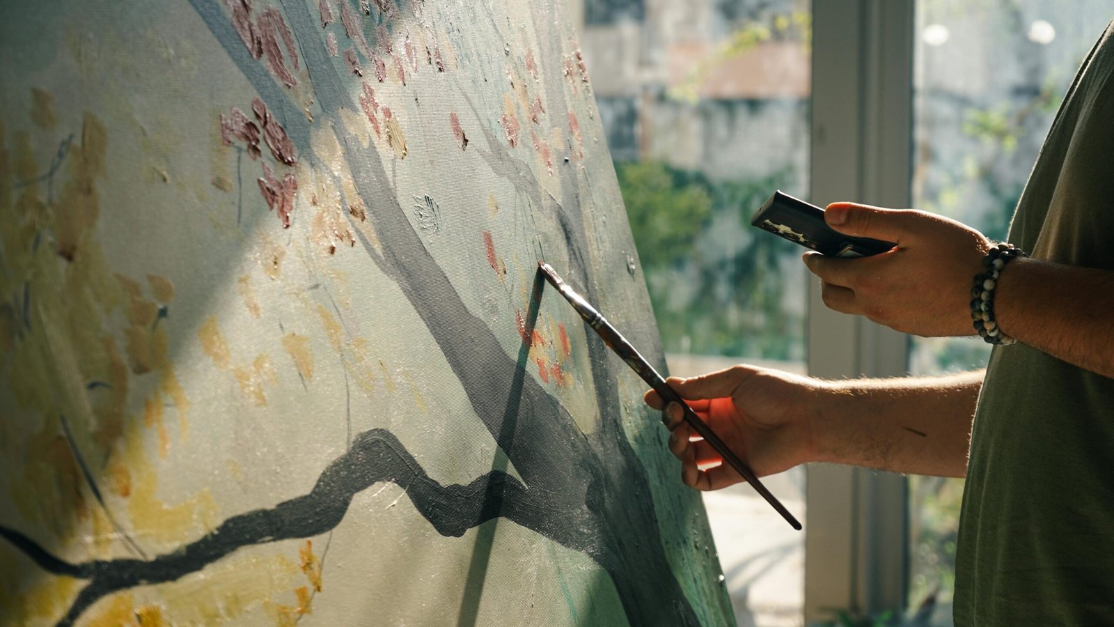 mano aplicando pintura en un lienzo grande